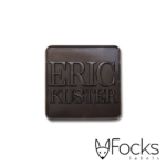 Eric Kuster merklabel, gegoten zinklegering in mat zwart vernikkeld, foamtape aan achterzijde.