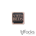 North Beds naamlabel, koper, achtergrond verdiept geëtst en ingelakt in 1 kleur. Machinaal gestanst, voorzien van boorgaten.